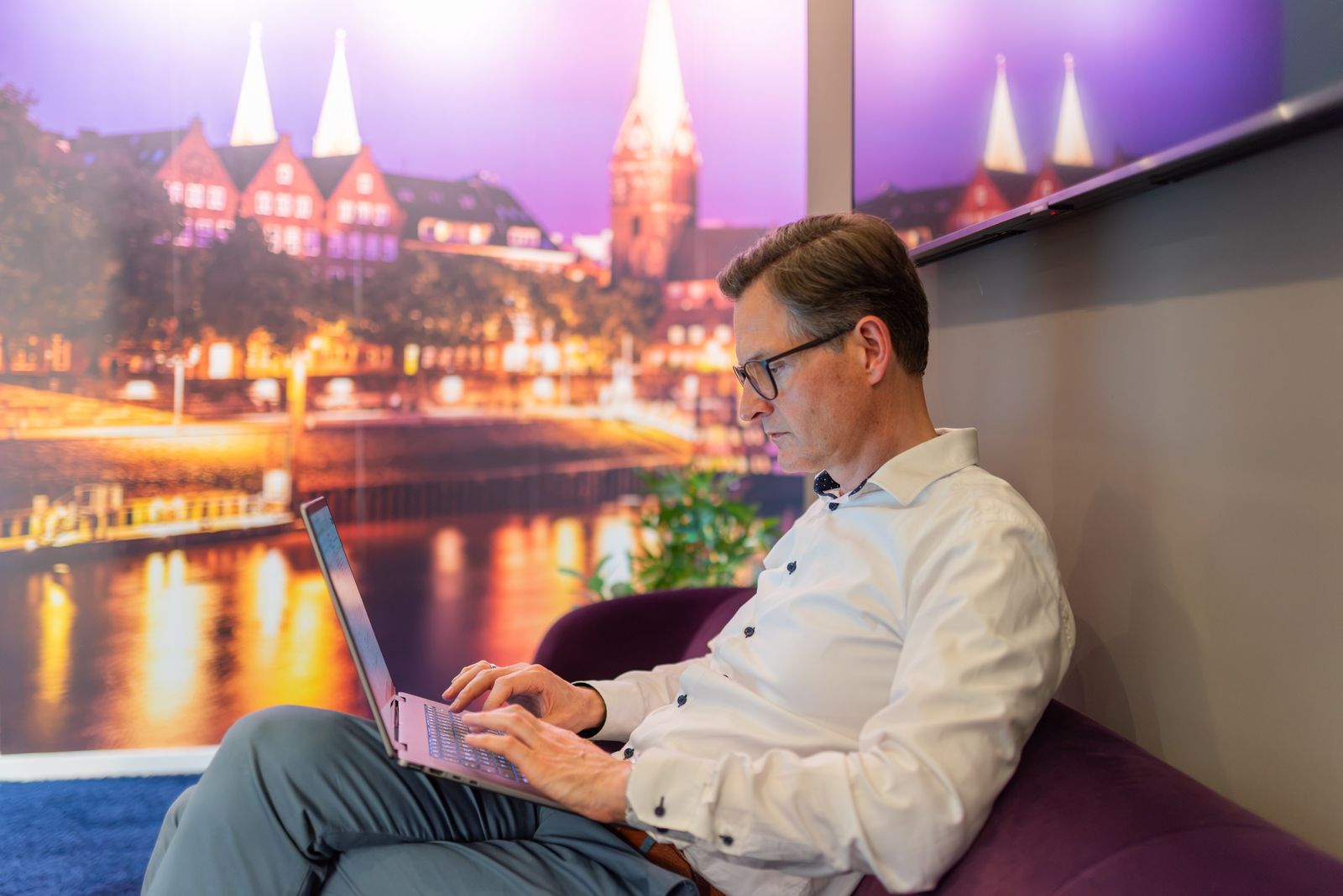 Sebastian Herbst am Laptop vor dem Bremen-Panorama
